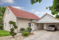 Einfamilienhaus mit Satteldach und Dachziegel J11v in toskanarot matt. Der Bildfokus liegt auf die Einfahrt, Garage und Hauseingang