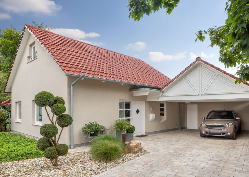 Einfamilienhaus mit Satteldach und Dachziegel J11v in toskanarot matt. Der Bildfokus liegt auf die Einfahrt, Garage und Hauseingang