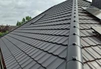 Z12v Reformziegel - neuestes Jacobi Dachziegel Modell- auf Walmdach mit Dachfenster in der Farbe samtschwarz mit Firstziegel im Fokus