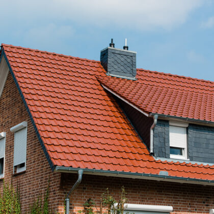 Sehr inspirierendes Mehrfamilienhaus mit Flachdachziegel J11v in der besonderen Mattglasur toskanarot matt auf Satteldach