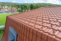 Mehrfamilienhaus mit Dachziegel von Jacobi J11v in altrot mit Bildfokus Knickziegel und Schneestopnasen