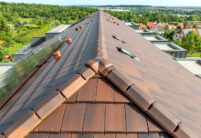 Stylischer Dachziegel, Stylist in der Sonderserie cottage auf besonderem Mehrfamilienhaus, mit Fokus auf die 3achsige Walmkappe aus unserem keramischen Zubehör