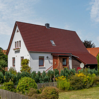 Satteldach von saniertem Einfamilienhaus mit Dachziegel J11v in edelweinrot in der Gesamtansicht