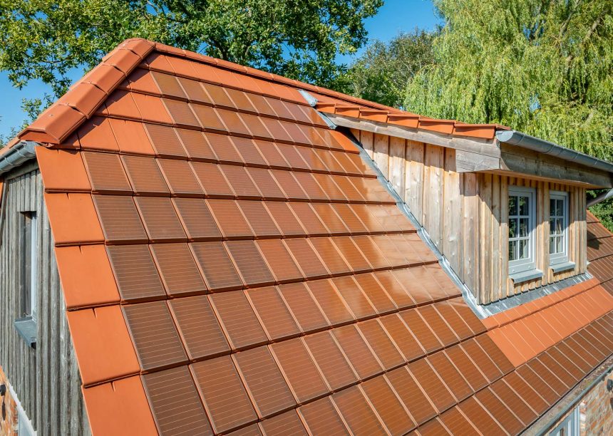 Traumhaftes Einfamilienhaus mit Klinkerfassade, Holzelementen und stilvollem Dach mit Solarziegel Stylist-PV in rotbraun mit Giebel- und Gaubendetails