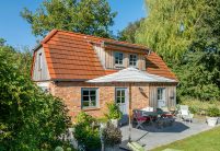 Traumhaftes Einfamilienhaus mit Klinkerfassade, Holzelementen und stilvollem Dach mit Solarziegel Stylist-PV in rotbraun mit Terrasseneinblick