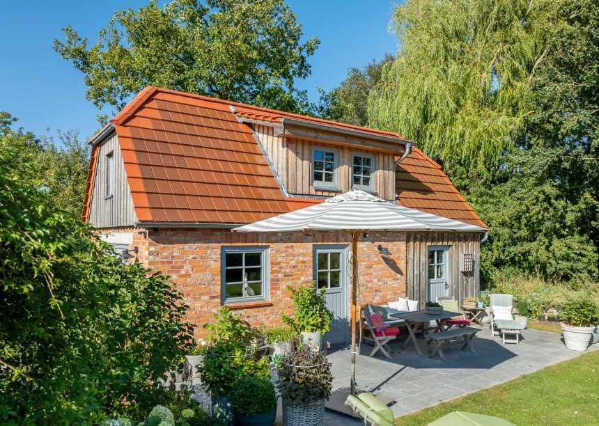 Traumhaftes Einfamilienhaus mit Klinkerfassade, Holzelementen und stilvollem Dach mit Solarziegel Stylist-PV in rotbraun mit Terrasseneinblick