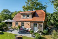 Traumhaftes Einfamilienhaus mit Klinkerfassade, Holzelementen und stilvollem Dach mit Solarziegel Stylist-PV in rotbraun