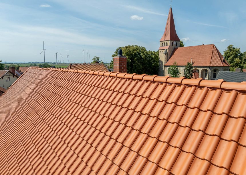 Historisches Haus mit Krüppelwalmdach und Fachwerk in der Gesamtansicht; mit Fokus auf die Firstreihe