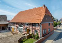 Historisches Haus mit Krüppelwalmdach und Fachwerk in der Gesamtansicht; mit Blick auf den Giebel; am Dach Z5 Dachziegel von Jacobi