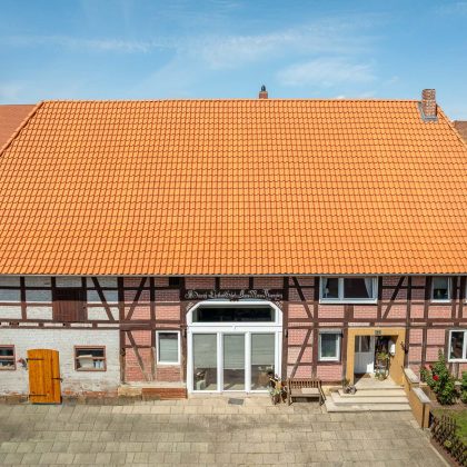 Historisches Haus mit Krüppelwalmdach und Fachwerk in der Gesamtansicht; am Dach Z5 Dachziegel von Jacobi