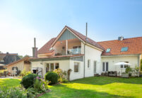 Einfamilienhaus mit Holzelementen und Flachdachziegel J13v in altrot auf dem Dach