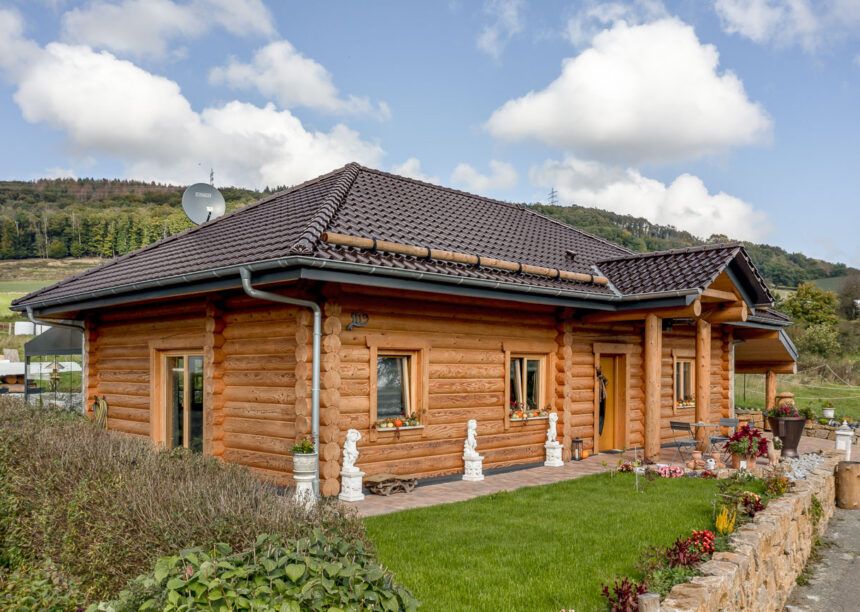 Rustikales Holzhaus mit Flachdachziegel J13v in vulkanschwarz auf dem Dach