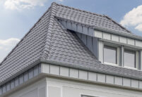 Wohnhaus mit Anbau und Flachdachziegel J13v in silbergrau auf dem Dach