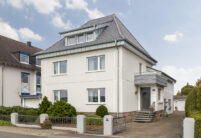 Wohnhaus mit Anbau und Flachdachziegel J13v in silbergrau auf dem Dach