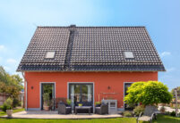 Rückansicht eines orangenen Haus mit Flachdachziegel J13v in schiefergrau matt