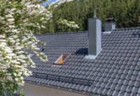 Detailaufnahme vom Dach eines Mehrfamilienhauses mit Flachdachziegel J13v in schiefergrau matt
