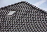 Detailansicht eines Daches gedeckt mit Flachdachziegel J13v in schiefergrau matt und First F6v