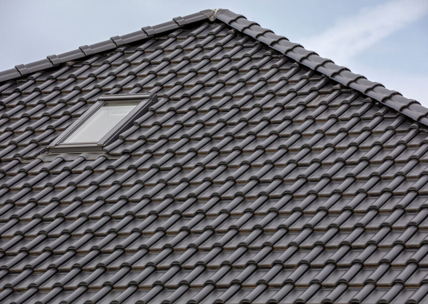 Detailansicht eines Daches gedeckt mit Flachdachziegel J13v in schiefergrau matt und First F6v