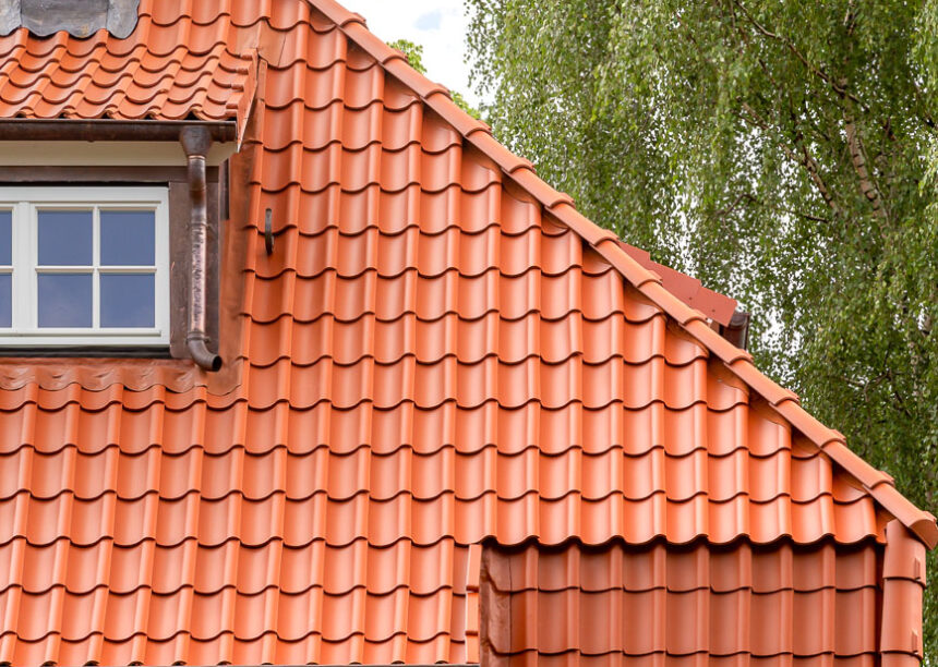 Haus mit Mansarddach und Hohlpfanne H2 in altrot hier mit Fokus auf den Grad mit unserem keramischen Zubehör