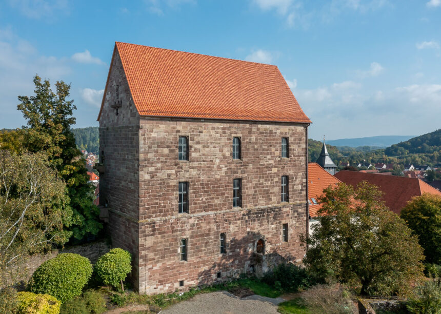 Historisches Muthaus mit Krempziegel K1 in Harzerbunt mit Dorfansicht im Hintergrund