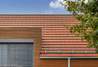 Flachziegel WALTHER Stylist® mit Dachziegeldetails in rotbraun auf Satteldach mit formschöner Gaube auf modernem Haus mit Holzverkleidung