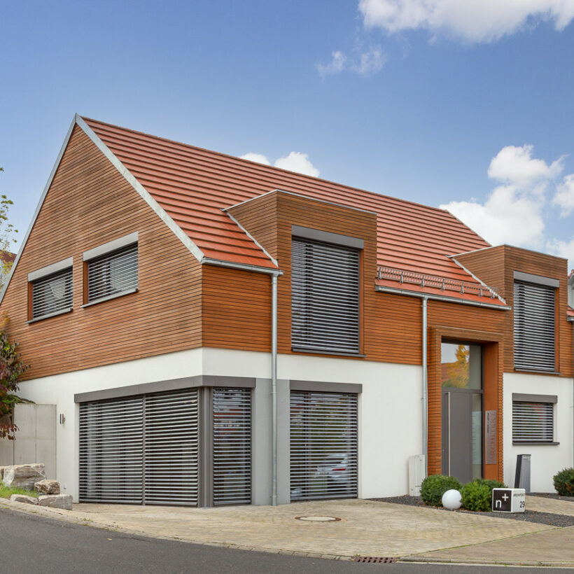 Einfamilienhaus mit Holzelementen und dem Flachziegel WALTHER Stylist in rotbraun auf dem Dach