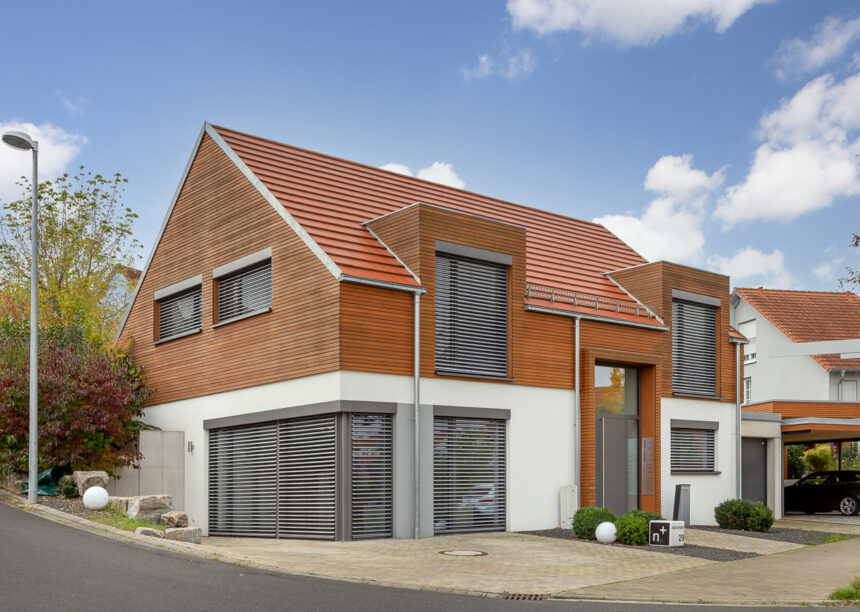 Einfamilienhaus mit Holzelementen und dem Flachziegel WALTHER Stylist in rotbraun auf dem Dach