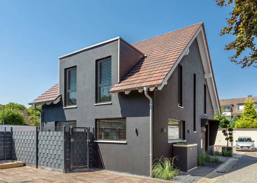 Traumhaus mit dunkler Fassade und Flachziegel in cottage in der Gesamtansicht