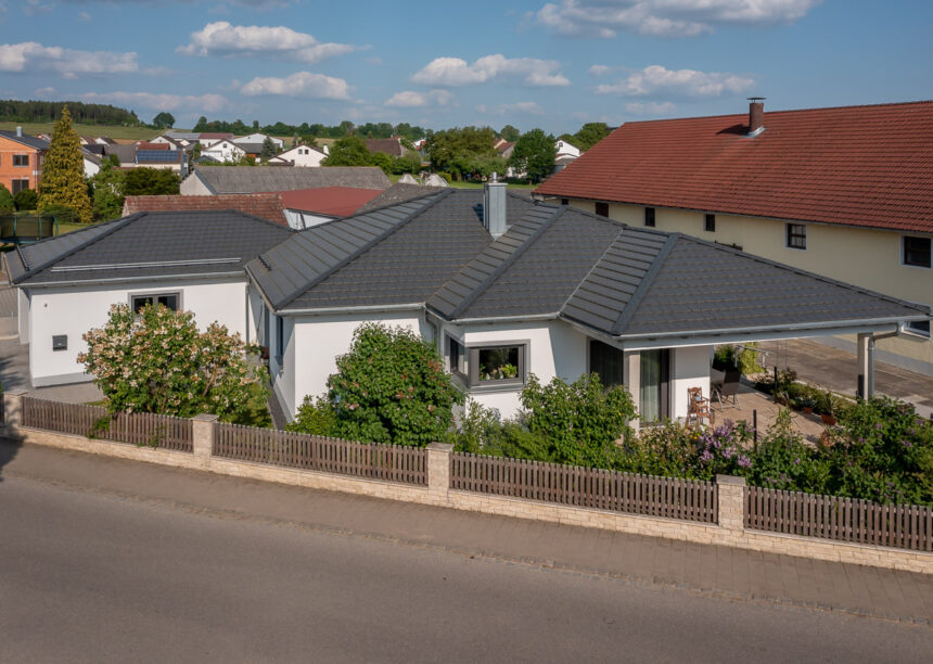 Ungewöhnliche Dachform trifft auf Flachziegel in edelschiefer auf stilvollem Bungalow.