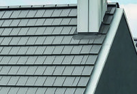 Satteldach mit Giebel eines Einfamilienhauses kombiniert mit edelschiefer Flachziegel und schwarzer Fassade