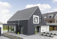 Schwarze Hausfassade eines Einfamilienhauses kombiniert mit edelschiefer Flachziegel