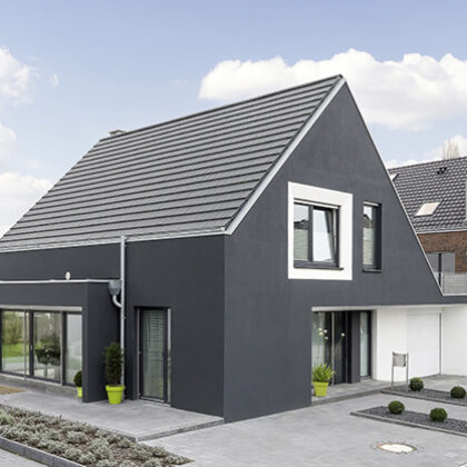 Schwarze Hausfassade eines Einfamilienhauses kombiniert mit edelschiefer Flachziegel