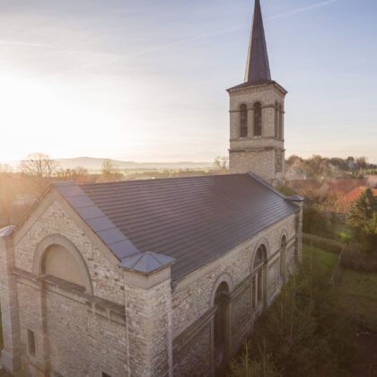 Historische Kirche mit minimalistischem Dachziegel in edelschiefer aus der Vogelperspektive