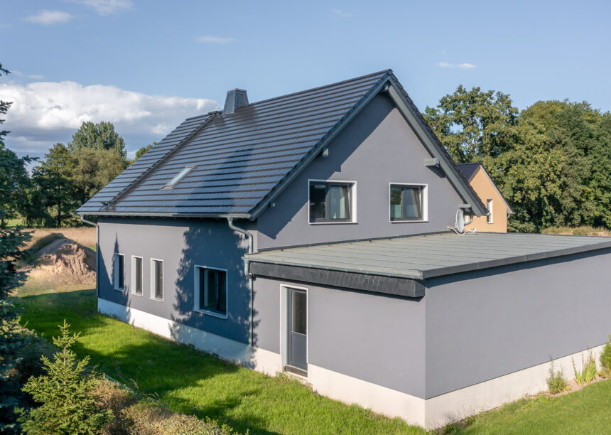 Schickes Einfamilienhaus mit dunkler Fassade und glitzernde edelspacegraue Dachfläche mit Ziegel Stylist und First Stylist