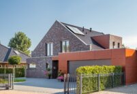 Gesamtansicht von schönem Klinkerwohnhaus mit anthraziten Flachziegel auf Klinkerhaus mit Details vom Giebel
