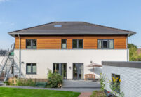 Einfamilienhaus mit zwei Vollgeschoßen, Holzverkleidung und auf dem Dach unser Walther Stylist in anthrazit frontal fotografiert