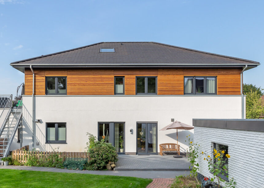 Einfamilienhaus mit zwei Vollgeschoßen, Holzverkleidung und auf dem Dach unser Walther Stylist in anthrazit frontal fotografiert