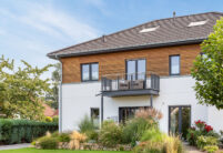 Einfamilienhaus mit zwei Vollgeschoßen, Holzverkleidung und auf dem Dach unser Walther Stylist in anthrazit