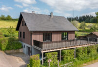 Holzhaus mit Flachziegel Stylist in samtschwarz