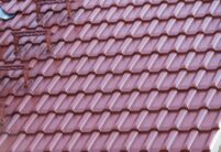 Satteldachgiebel von hochwertig saniertem Einfamilienhaus, gedeckt mit Dachziegel W6v in edelmarone, im Bildfokus das filigrane Deckbild des Ziegels