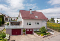 Einfamilienhaus mit Flachdachziegel W6v auf diesem Foto in der Gesamtansicht mit Garage und Dachterrasse.