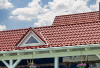 Dieses farbenfrohe Einfamilienhaus strahlt dank der Edelengobe edelrosso hier mit Fokus auf die Dachgaube.