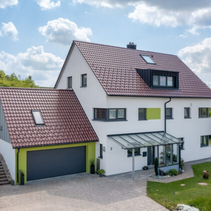 EFH mit hochwertigem Dach dank vollkeramischen Firstlösung (FAL) und Edelengobe edelrosso. Gedeckt mit Flachdachpfanne W6v.