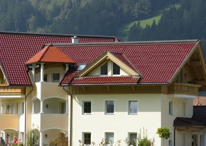 Ein Hotel gedeckt mit den Dachziegelmodell W6v in edelrosso, das Satteldach hat ein Turmdach und mehrere Gauben