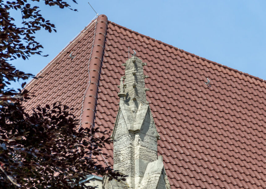 Kirche mit Flachdachziegel W4v in der Engobe kupferbraun auf dem Foto Details vom Walmdach und Deckbild