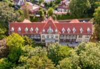 Erholungshaus Seniorenresidenz mit Doppelmuldenfalzziegel Tradition in rotbraun aus der Luft.