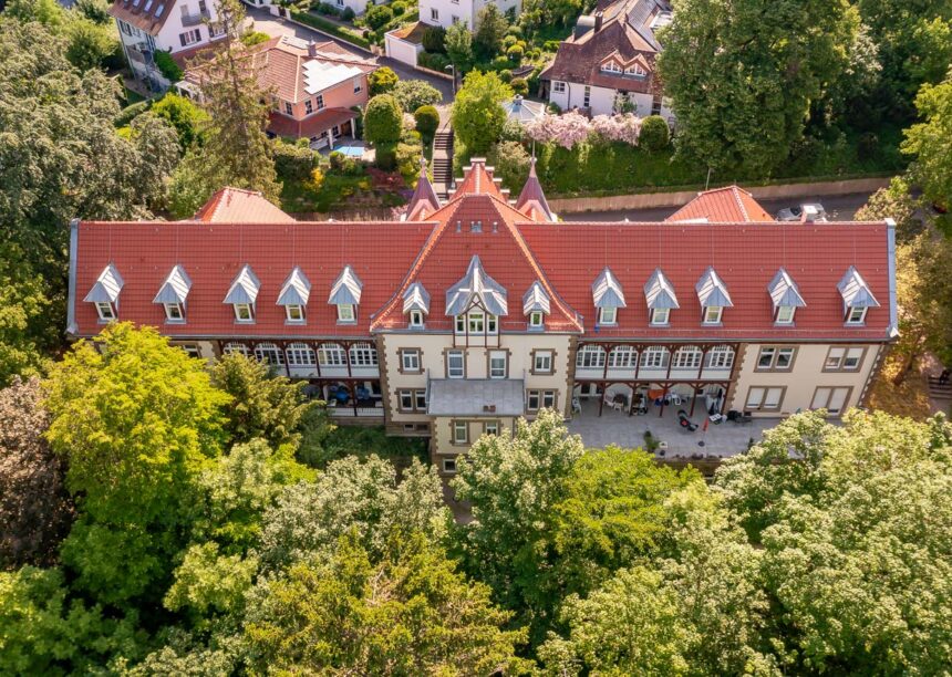 Erholungshaus Seniorenresidenz mit Doppelmuldenfalzziegel Tradition in rotbraun aus der Luft.