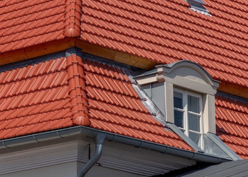 Tradition in rotbraun auf Mehrfamileinhaus mitten in der Stadt - der Dachziegel von Jacobi im Doppelmuldendesign. Im Bildfokus der formschöne Gradanfänger in Muschelform aus dem keramischen Jacobi-Zubehör