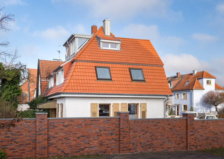 Saniertes Einfamilienhaus mit Mansarddach in naturrot von der Straßenansicht fotografiert