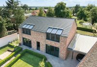 Dachziegel Stylist in edelschiefer auf modernem Klinkerhaus, hier in der Gesamtansicht mit Garteneinblick